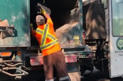 Garbage man throwing garbage into garbage truck